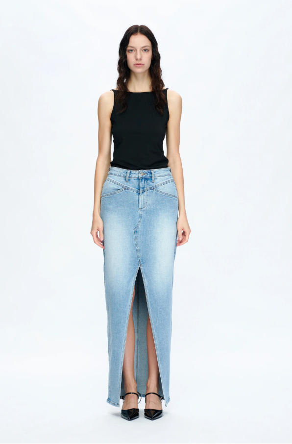Woman wearing a black sleeveless top and light blue denim skirt on a white background